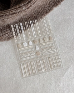 Gros plan d'autocollants pour ongles 5D avec motifs de pull en tricot et bonnet en relief