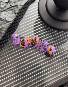 Close-up of Halloween nail art stickers with purple pumpkin and spooky castle patterns