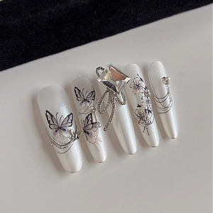 Elegant pearl white press-on nail set with butterfly patterns and crystal diamond accents