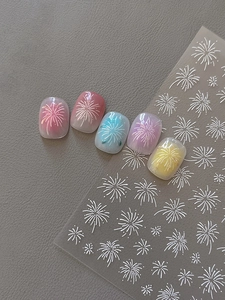 Detailed view of white firework embossed nail stickers on multicolored manicure tips