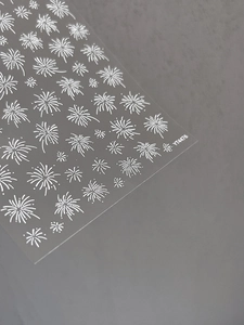 Close-up of white fireworks embossed nail art stickers with delicate lines on grey base