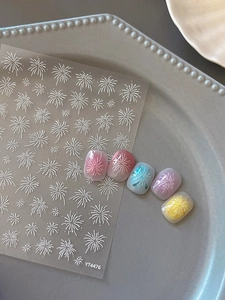 Detail of white embossed fireworks nail stickers with delicate floral line art designs