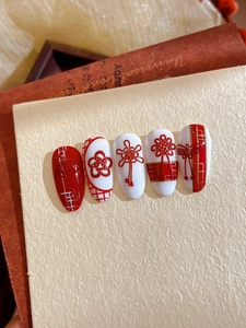 Detail of red and white 3D nail stickers featuring Chinese knot and floral relief patterns