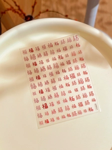 Dettaglio di adesivi nail art con calligrafia cinese Fu rossa su vassoio in ceramica