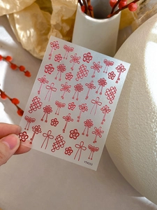 Detail of red Chinese knot embossed nail art stickers with plum blossom patterns