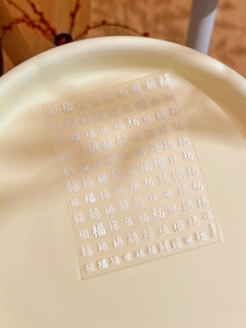 Macro di adesivi per unghie con carattere Fu in rilievo argento in una ciotola di ceramica