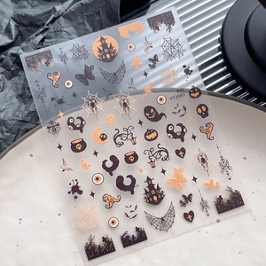 Halloween nail art stickers featuring ghost, pumpkin, and castle designs on white ceramic plate