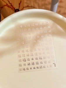 Dettaglio macro di adesivi per unghie con calligrafia Fu dorata a rilievo su piatto beige
