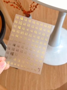Dettagli di adesivi per unghie con caratteri Fu in rilievo dorati in vari stili calligrafici