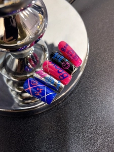 Detail view of colorful street graffiti nail stickers with boo and haha text on metal stand