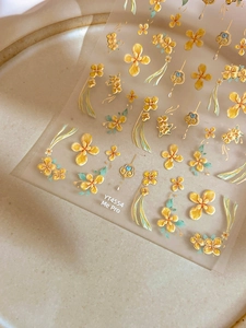 Dettaglio ravvicinato di adesivi per unghie 5D con fiori gialli a rilievo