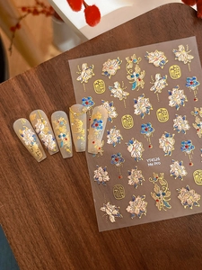 Detail of embossed peony nail stickers with gold Fu characters on long acrylic nails