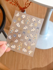 Close-up of gold embossed peony nail stickers with Chinese characters and floral motifs