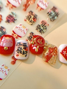 Macro detail of 3D lucky cat nail stickers with embossed red and gold New Year patterns