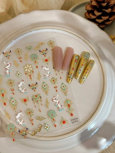 Detail of Chinese style gold nail stickers with lotus and cloud patterns on white plate