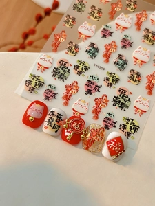 Detail showing 3D embossed Lucky Cat nail stickers with traditional Chinese New Year motifs