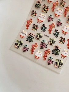 Detail of embossed Lucky Cat nail stickers with Chinese traditional festive patterns