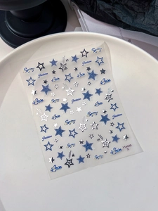 Vue macro détaillée des autocollants à ongles étoiles argentées avec polices bleues