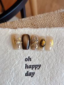 Macro view of bronzing embossed floral nail stickers with cat-eye and amber gemstone effects