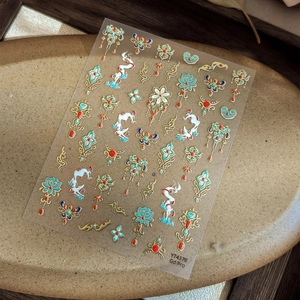 Golden lotus nail art stickers with traditional Chinese patterns on ceramic plate