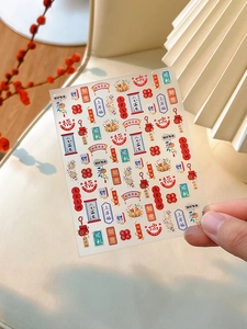 Detail of Year of the Snake nail art stickers with red and gold traditional motifs