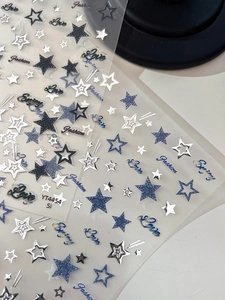Détail des stickers à ongles étoiles argentées avec motifs bleu denim et holographiques