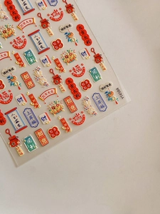 Macro detail of 3D embossed Chinese New Year nail stickers with gold and red motifs