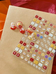 Close-up of 3D embossed Lucky Cat nail art stickers with red and gold festive patterns