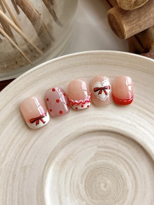 Detail of sweet 3D bow nail art stickers with red hearts and polka dot patterns