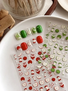 Détail de stickers 3D pour ongles aux motifs de pommes rouges et vertes avec touches florales