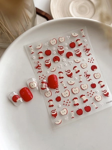 Vue détaillée de stickers pour ongles gaufrés pommes et fleurs avec faux ongles rouges