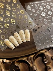 Detailed macro view of gold baroque nail stickers with vintage embossed patterns