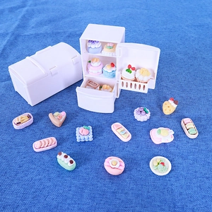 Mini réfrigérateur de maison de poupée blanc avec desserts miniatures sur tissu bleu