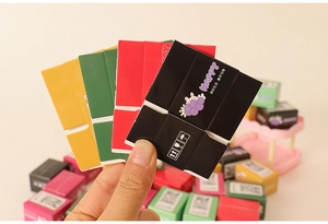 Detailed macro of colorful miniature 1:12 dollhouse shipping boxes held by hand