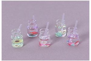 Macro view of five miniature resin fruit juice bottles with straws for DIY crafts