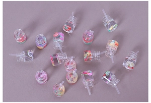 Macro shot of miniature resin juice bottles with fruit slices and straws for DIY crafts