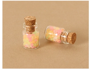Close-up of miniature dollhouse glass jars with cork stoppers and colorful candy beads