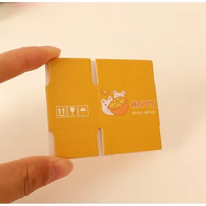 Close-up of a 1:12 yellow miniature blind box with rabbit illustration and logistic icons