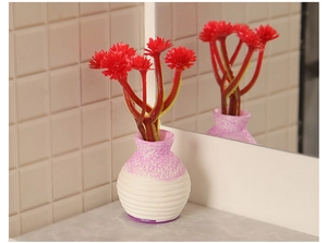 Miniature dollhouse potted plant with red flowers in a pink gradient ceramic vase