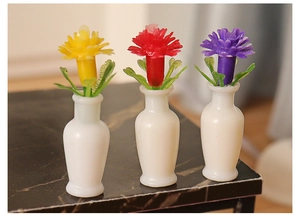 Detailed macro view of three miniature dollhouse flower vases with colorful resin blossoms