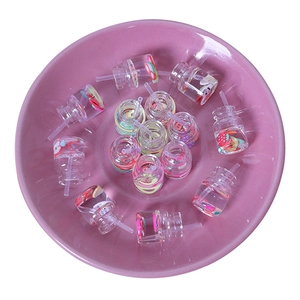 Miniature resin juice bottles with fruit slices for DIY crafts in a pink ceramic dish