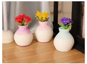 Detailed view of three miniature dollhouse flower pots with colorful floral arrangements