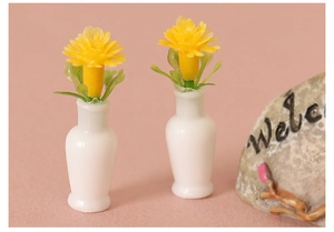 Miniature dollhouse vases with yellow daisies on a pink background for DIY crafts