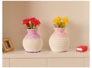 Detailed macro view of miniature dollhouse vases with red and yellow faux flowers