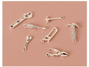 Detailed view of silver miniature tool charms including hammer and wrench for DIY crafts
