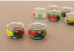 Detailed close-up of miniature dollhouse glass fish tanks with koi and aquatic plants