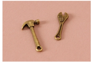 Macro shot of miniature bronze claw hammer and adjustable wrench for DIY dollhouse crafts