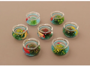 Detailed macro view of seven miniature glass fish tanks with colorful goldfish and aquatic plants