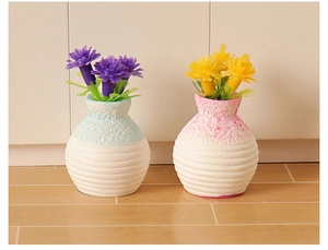 Close-up of miniature blue and pink ceramic flower vases with textured white base details