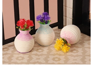 Macro shot of miniature dollhouse vases with colorful resin flowers on tiled floor